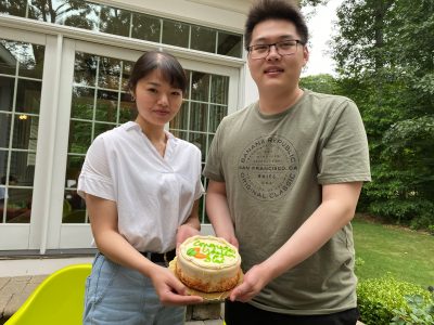Two lab members holding a cake